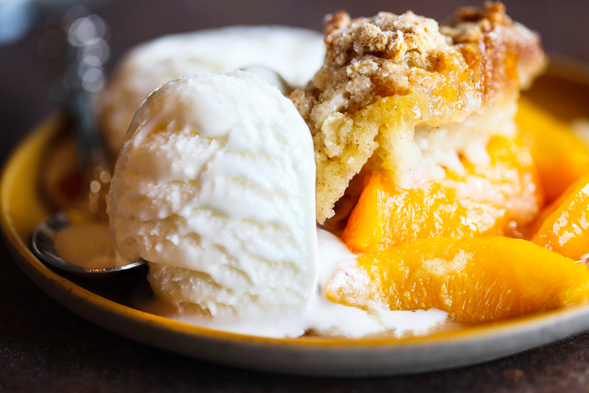 Drop biscuit peach cobbler with melting ice cream